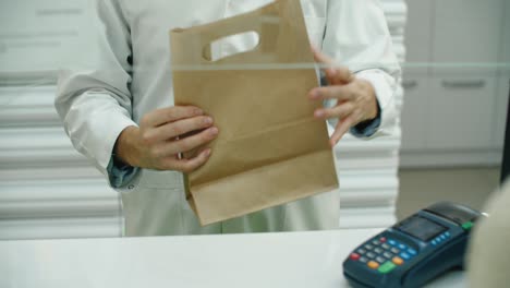la compra de medicamentos en la farmacia. la farmacia entrega el paquete con el medicamento.