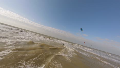 Aerial-drone-flight-after-kite-surfer-riding-rough-waves-in-strong-wind