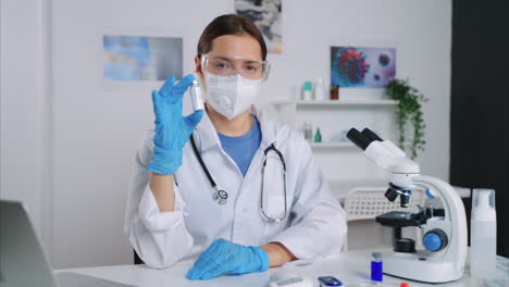 médico sosteniendo el vial en el laboratorio