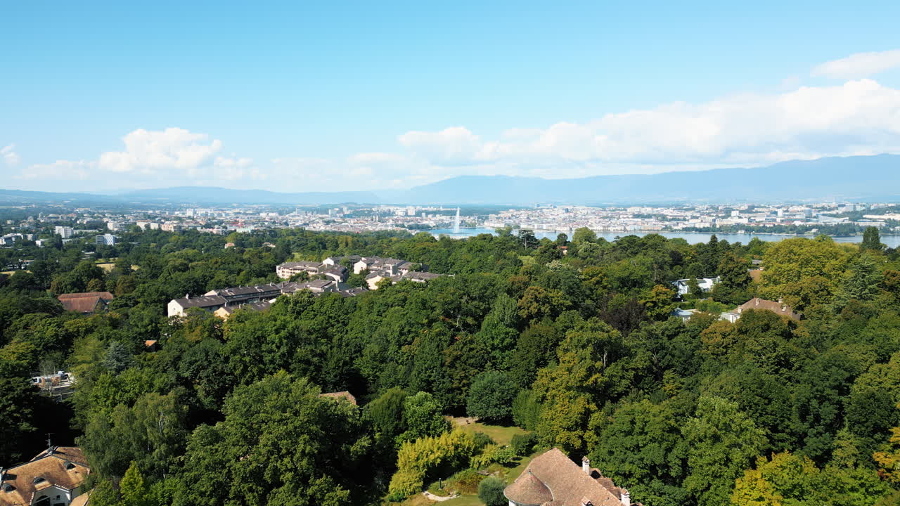 Establishing drone shot of water fountain of Geneva during the day (Rade of Geneva) from Cologny, Switzerland