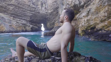 un joven en buen estado está en la playa.