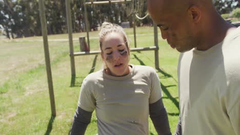 Tired,-diverse-male-and-female-soldier-resting-on-army-obstacle-course-in-sun