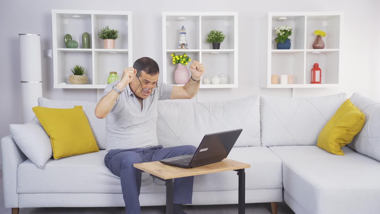 el anciano mirando la computadora portátil se regocija.