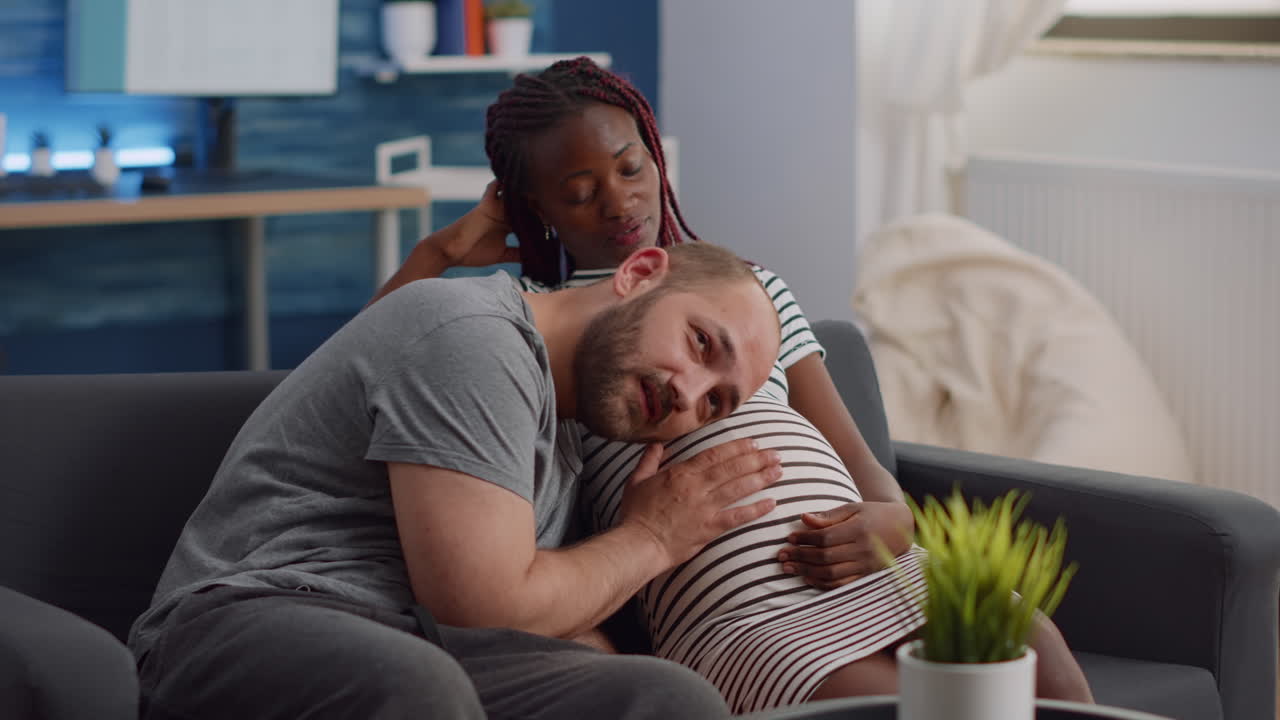 Interracial couple expecting child in living room
