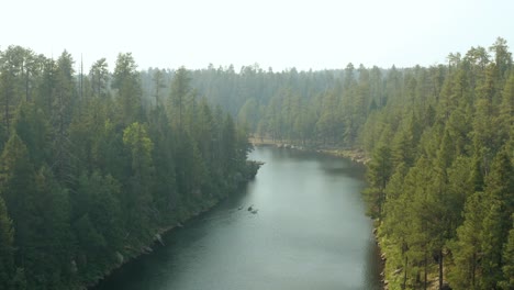 Hidden-dense-forest-lake-with-kayak-paddlers-exploring