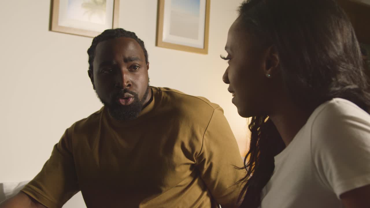 Couple At Home Sitting On Bed At Night Having Argument 3