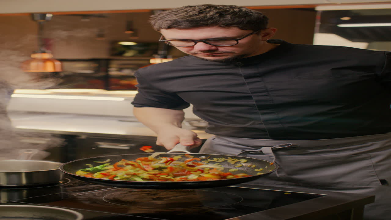 Chef che Sala e Salta Verdure in Padella nella Cucina di un Ristorante