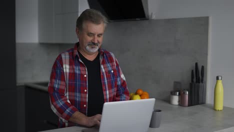 Anciano-Barbudo-Usando-Una-Laptop-En-La-Cocina