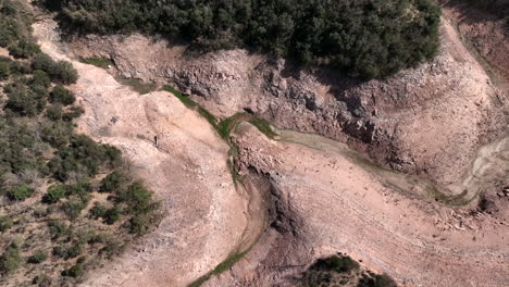 Top-down-aerial-view-of-water-reservoir-dry-bed,-extreme-drought-of-Europe