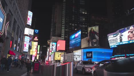 luminous time square advertising at night in new york city - camara moving forwards