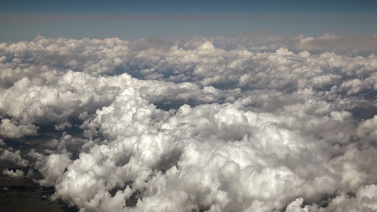 Aerial View of Dense White Clouds from Airplane Window