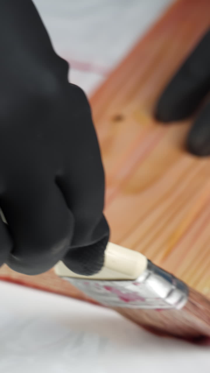 Applying Stain to Wood with Protective Gloves