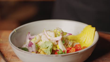 preparación de ceviche - toma en cámara lenta de un toque final del chef en el plato tradicional peruano agregando cilantro para adornarlo, concepto de escena de cocina