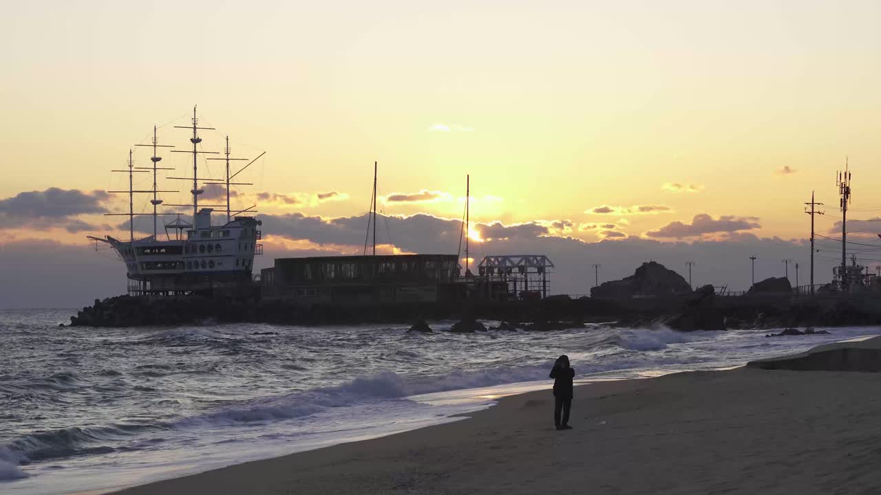 Sea shore of South Korea during sunrise (towards East Sea).  Person, ship, sea waves, clouds and sunrise. Shot with Sony a7iii 4k with 29.97fps .