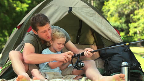 father teaching his son how to fish