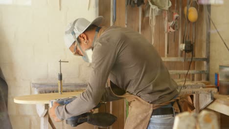 surfboard maker using polisher machine on surfboard 4k