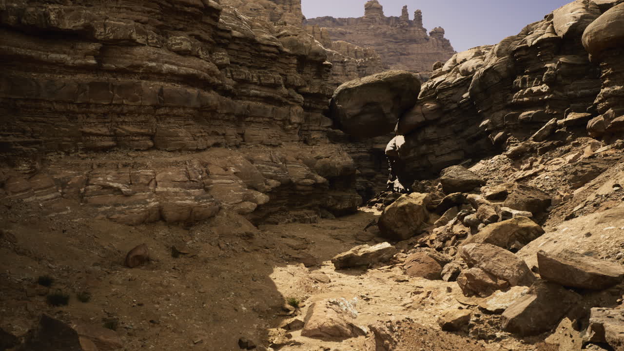 Rocky canyon landscape with towering cliffs under a clear blue sky