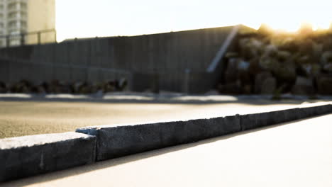 sunset over urban pavement with textures and rocks in background