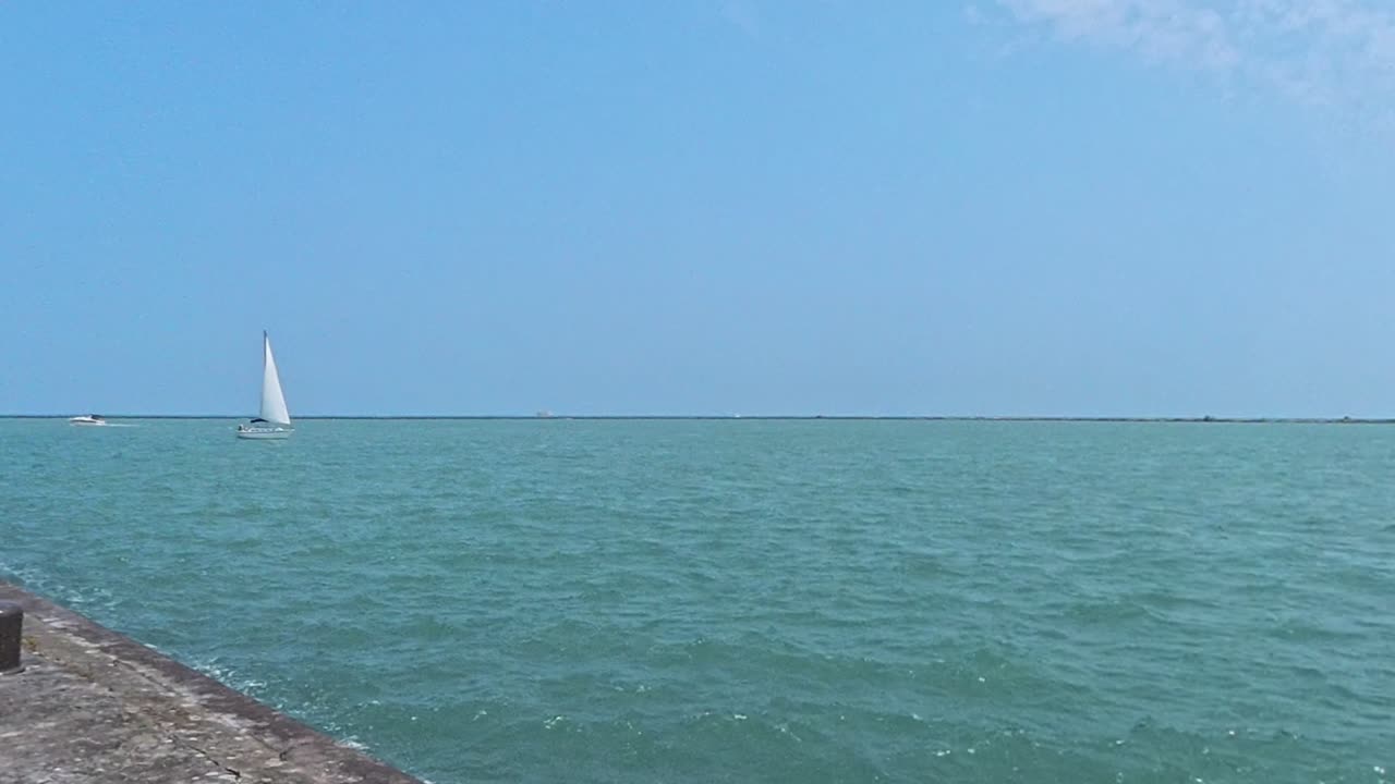 Sailboat floating along the sea at the end of the Navy Pier in Chicago