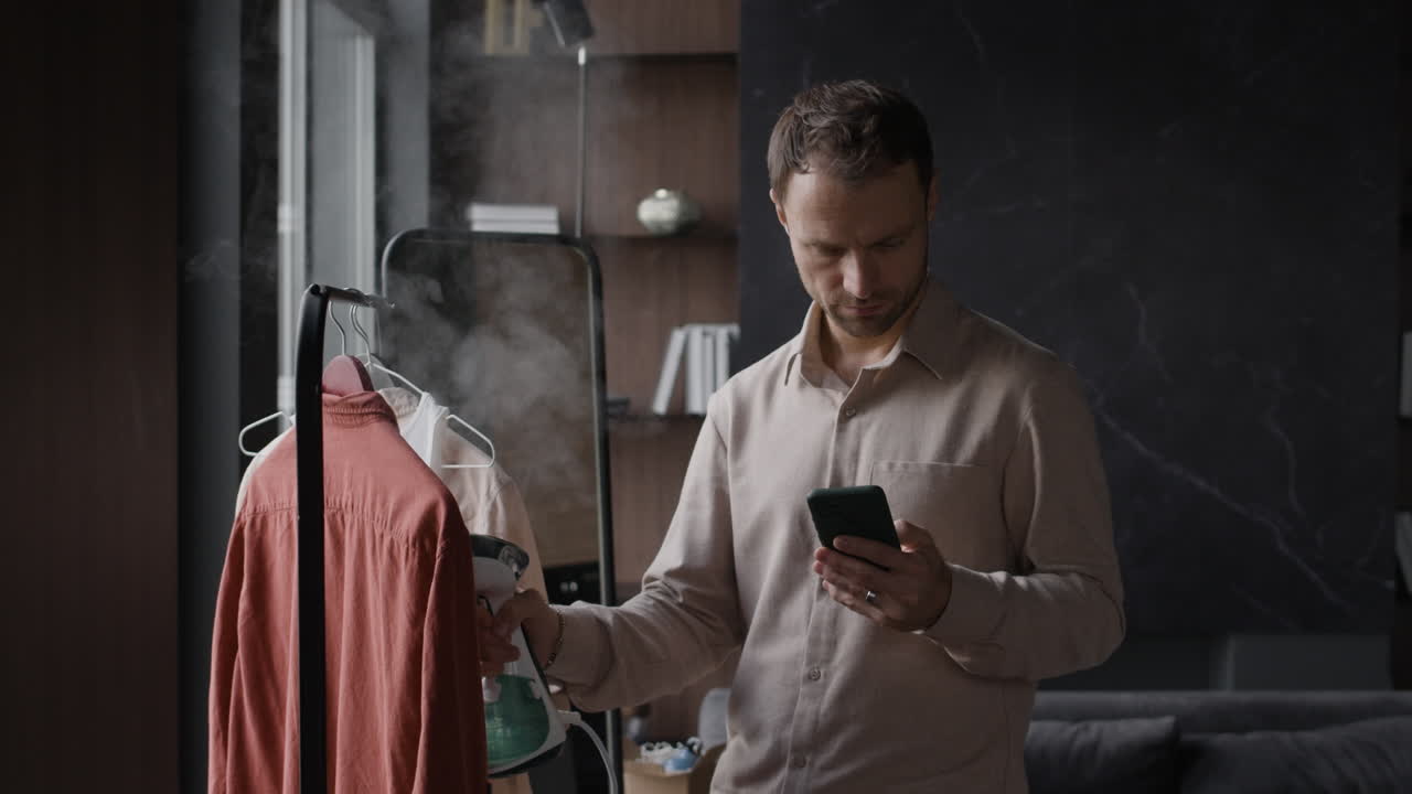 Man using a steamer while on his phone