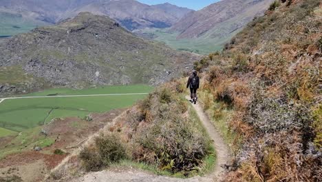 Middle-aged-Latina-woman-hiking-down-a-mountain-on-a-beautiful-clear-day-in-Wanaka-New-Zealand