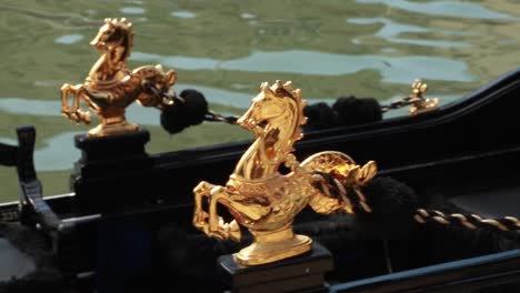 venetian gondola's golden horse shaped handles in venice, italy