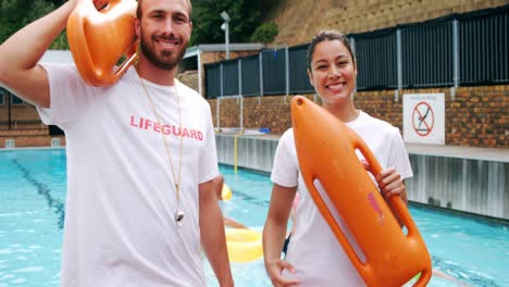 swim coaches standing with inflatable floater near poolside