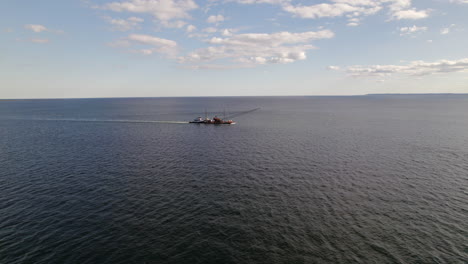 Vuelo-Aéreo-Hacia-La-Plataforma-De-Grúa-Flotante-Empujada-Por-Un-Remolcador-Frente-A-Coney-Island,-Nueva-York