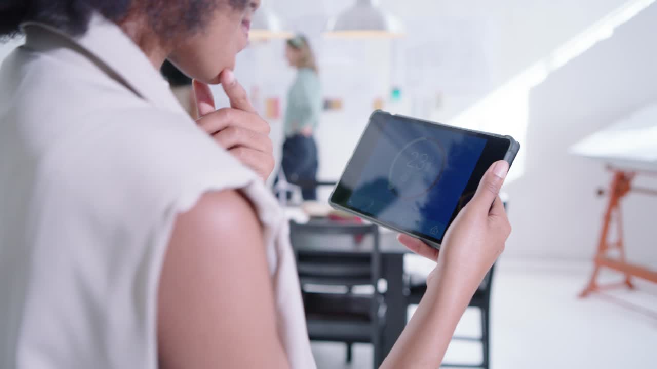 Diverse female team tapping tablet 23° pausing walking to board organizing notes for design review