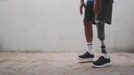 vista de sección baja hombre con pierna protésica corriendo y descansando