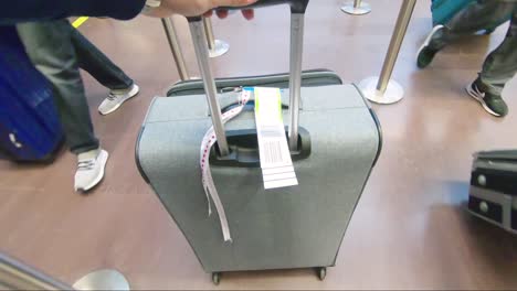 a passenger pushing the luggage on wheels in slow motion at the baggage drop in the airport