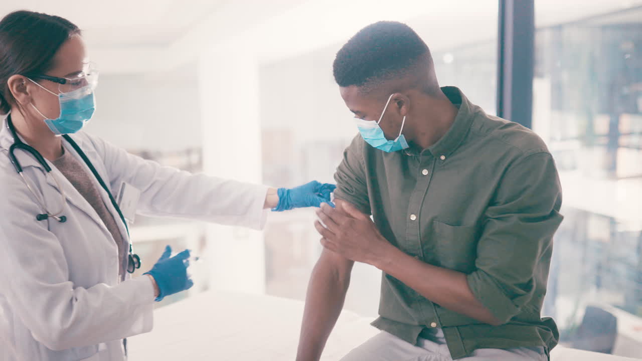Doctor administering a vaccine to a patient wearing a mask