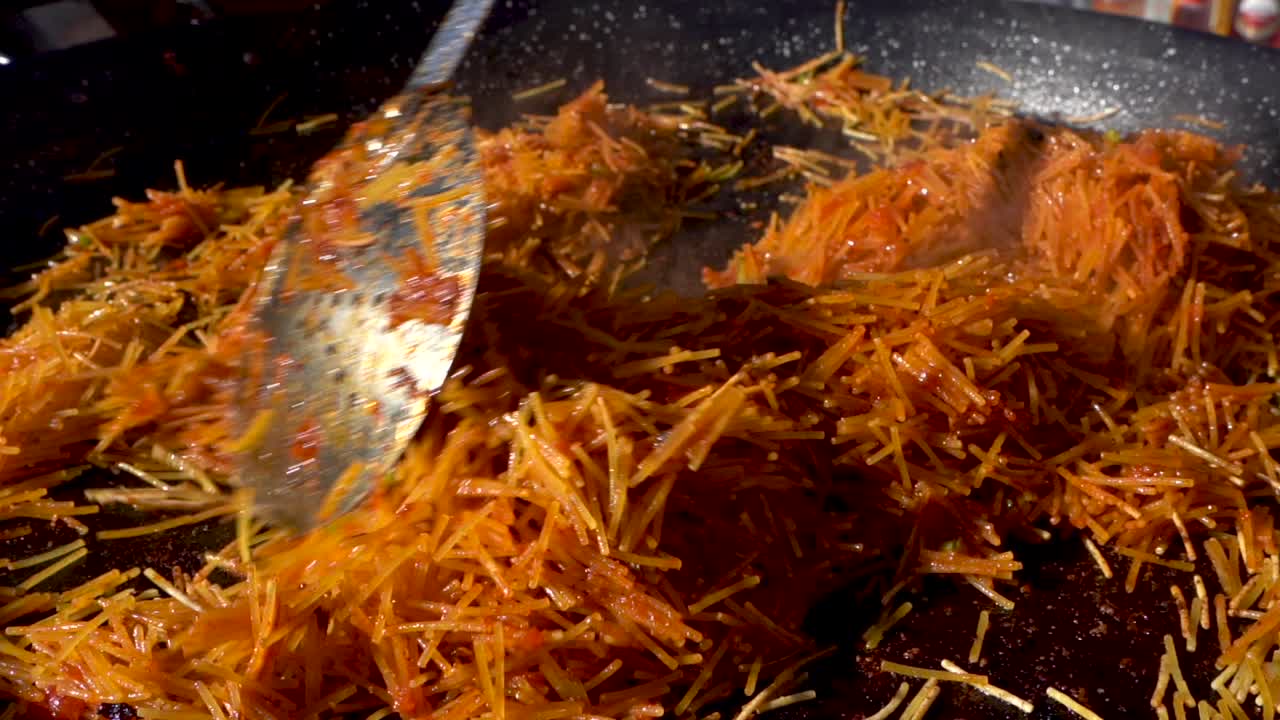 Lezzetli bir paella yapmak için tavada makarna hazırlığı.