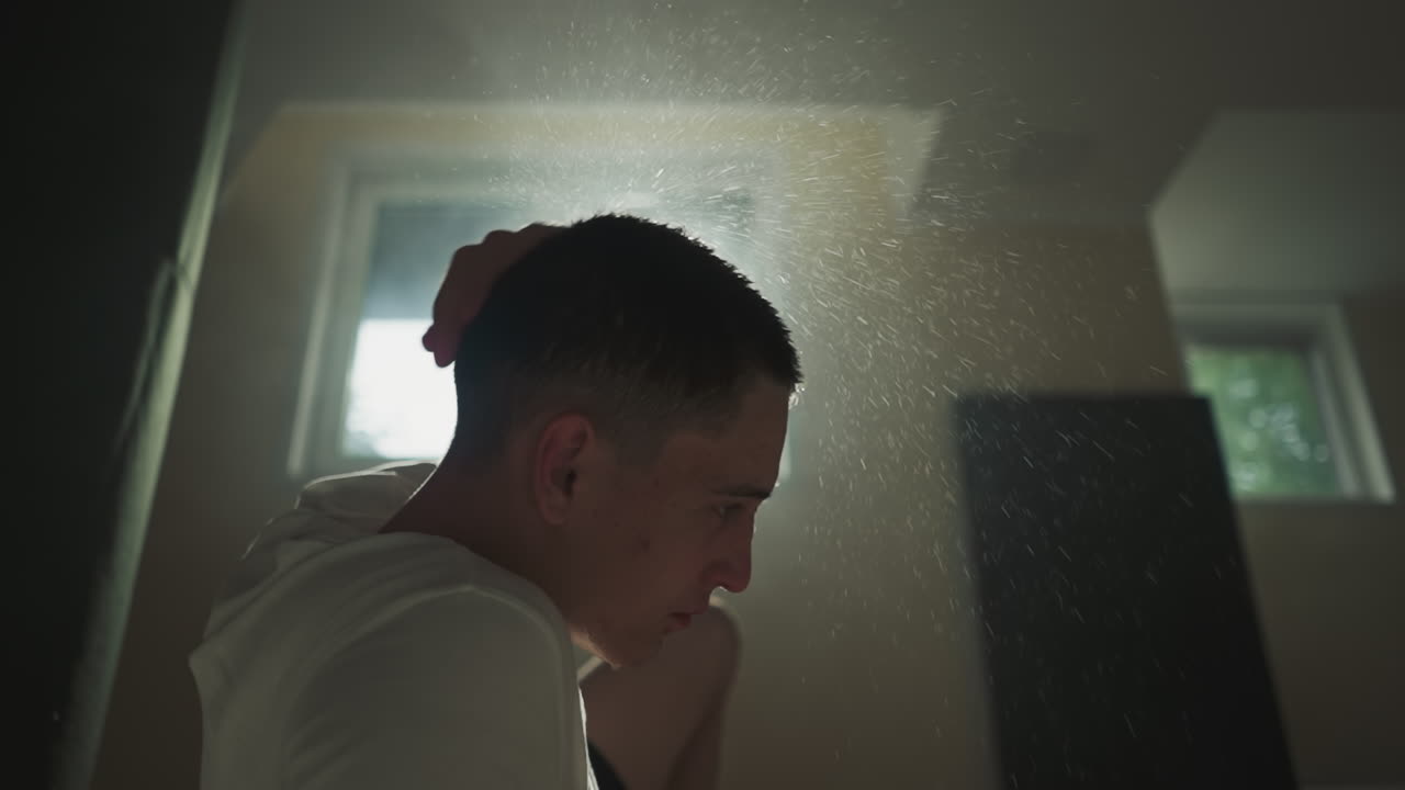 격렬한 권투 세션 후에 피곤한 남자는 으로 짧은 머리카락을 흔들고 스포츠 클럽에서 바닥에 떨어지는 물방울 스플래시.