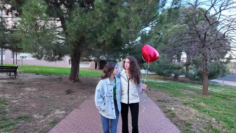 two women walking with a heart balloon