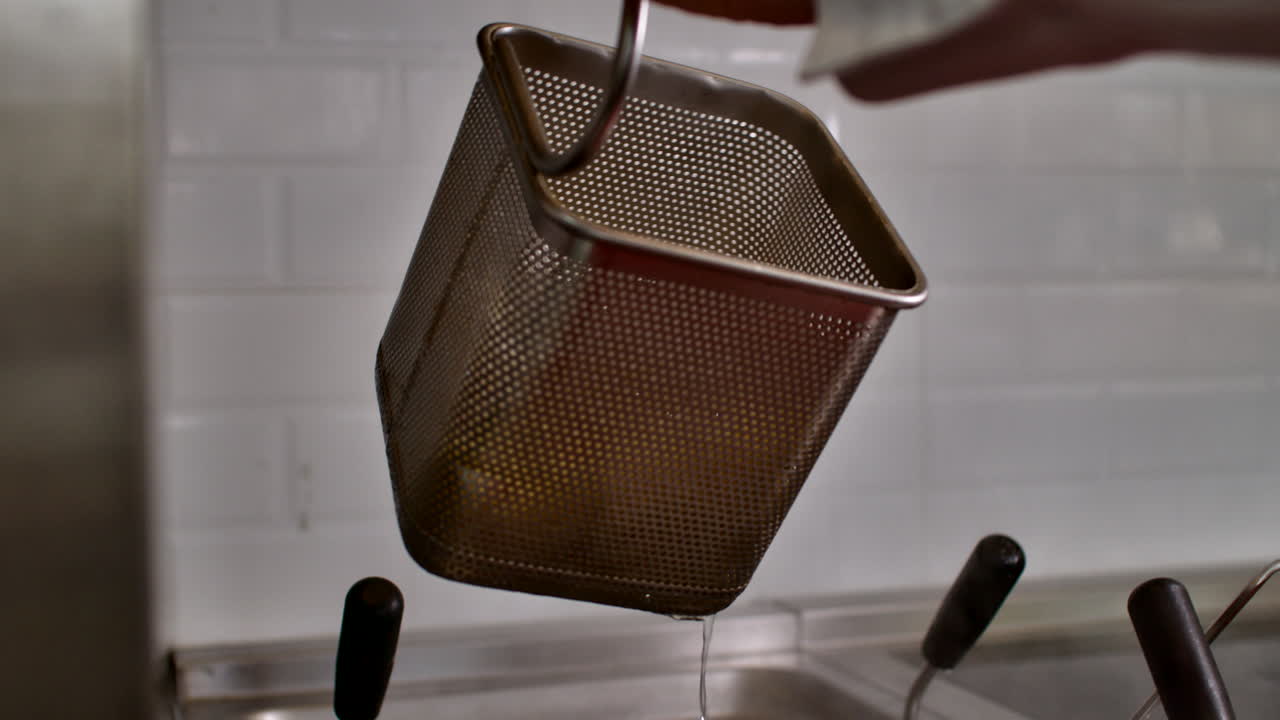 Primo piano di acqua bollente scolata da un cestello scolapasta professionale