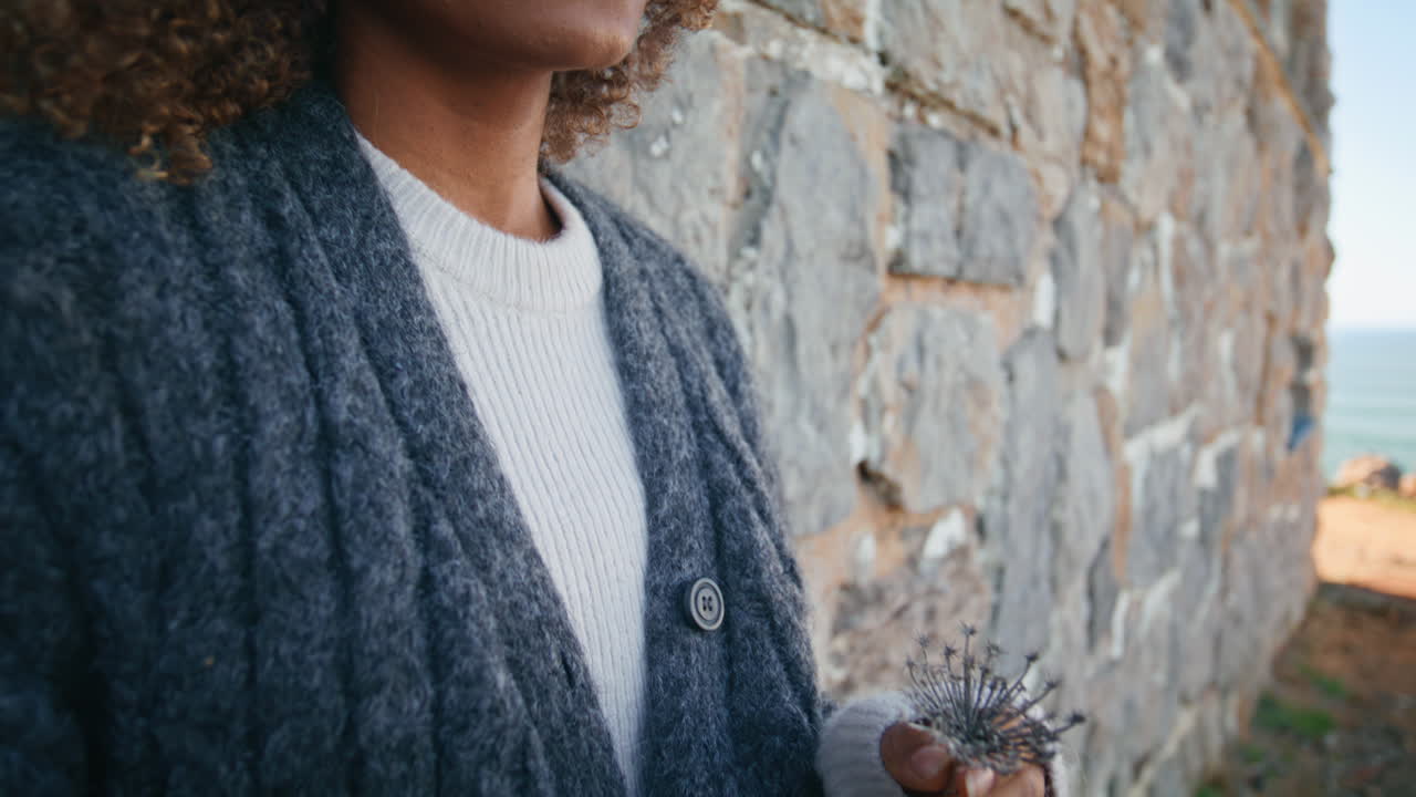 Pensive lady pondering alone at old building background closeup. Sad curly woman