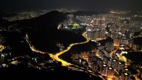 a breathtaking drone view of hong kong at night, showcasing the glowing skyline, busy harbor, and vibrant city lights from above.