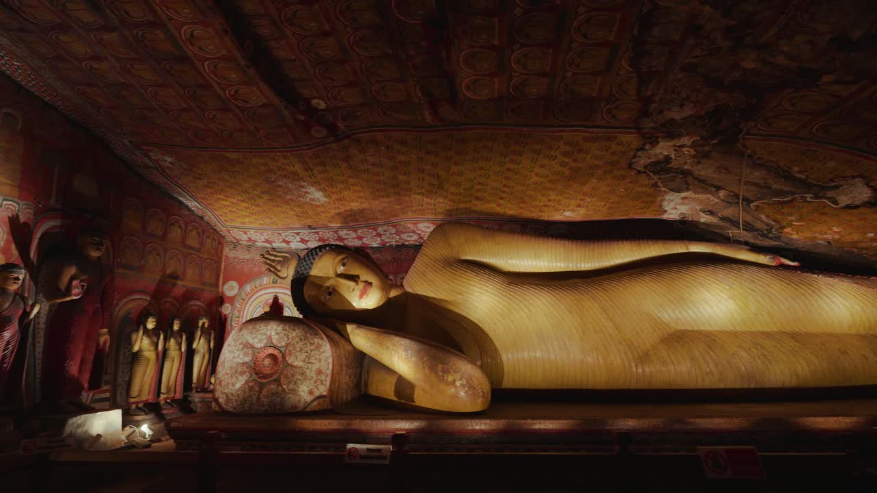 Interno del Tempio rupestre di Dambulla in Sri Lanka che mostra antichi murales e sacre statue di Buddha.