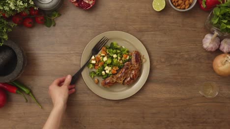 persona de la cosecha poniendo tenedor en el plato con ensalada y salchichas