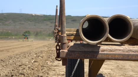 Tractor-Agrícola-Se-Mueve-A-Través-De-Un-Paisaje-Seco-Y-Polvoriento-En-California,-Lo-Que-Sugiere-Sequía-Y-Cambio-Climático-2