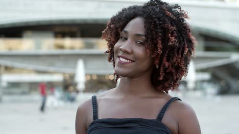 Front-view-of-smiling-woman-posing-on-street