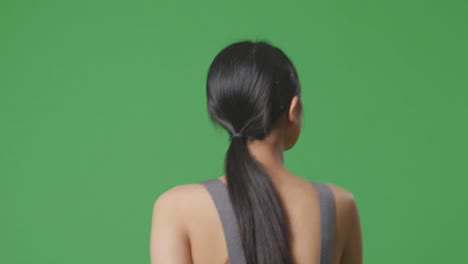 woman with ponytail from behind on green screen