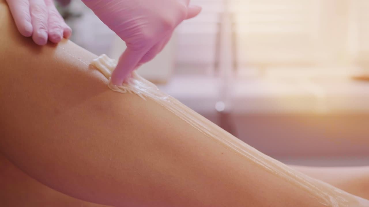 depilación de piernas femeninas con miel o pasta de azúcar. depilación de azúcar. concepto de belleza. azúcar. proceso de depilación. piernas.