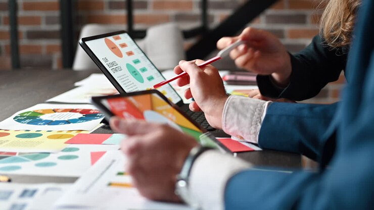 Un uomo e una donna analizzano un grafico su un tablet a un tavolo in un ufficio