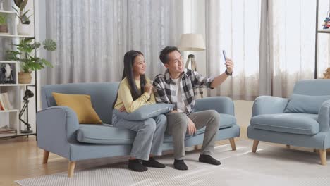 couple taking selfie on a sofa