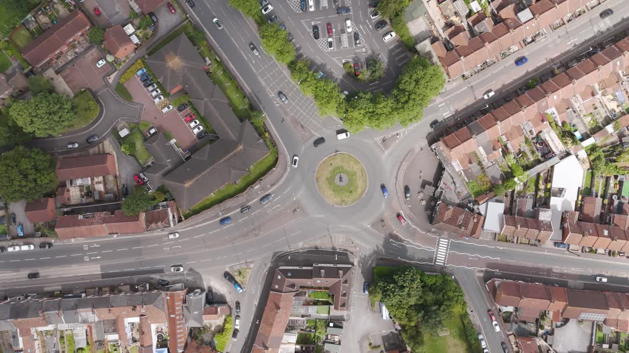 Top down drone aerial view of a busy roundabout surrounded by residential streets, showcasing traffic movement and urban layout in Bridgwater, United Kingdom