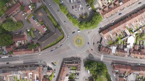 Top-down-drone-aerial-view-of-a-busy-roundabout-surrounded-by-residential-streets,-showcasing-traffic-movement-and-urban-layout-in-Bridgwater,-United-Kingdom