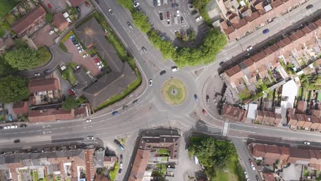 vista aérea de arriba hacia abajo de un dron de una rotonda ocupada rodeada de calles residenciales, mostrando el movimiento de tráfico y el diseño urbano en bridgwater, reino unido