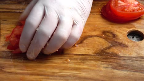 the cook cuts tomatoes on a cutting board.